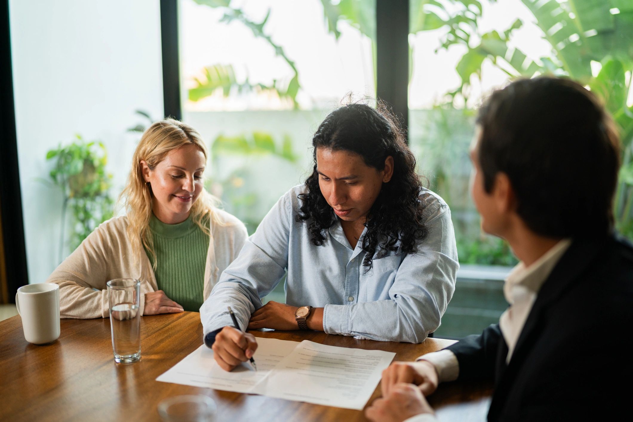 Couple signing home purchase documents with a real estate professional